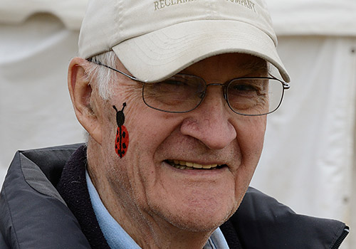 Man with ladybug facepaint on cheek