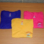 Three v neck shirts, in different colors, with small Marshy Point logo on front