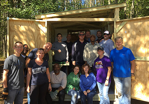 Company volunteers in front of newly built enclosure